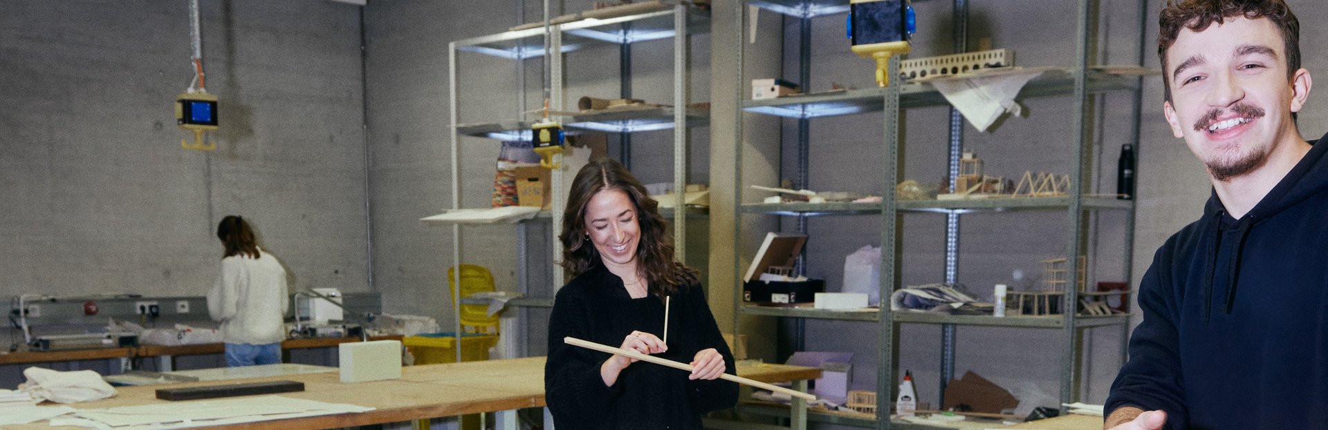 Three students are building an architectural model