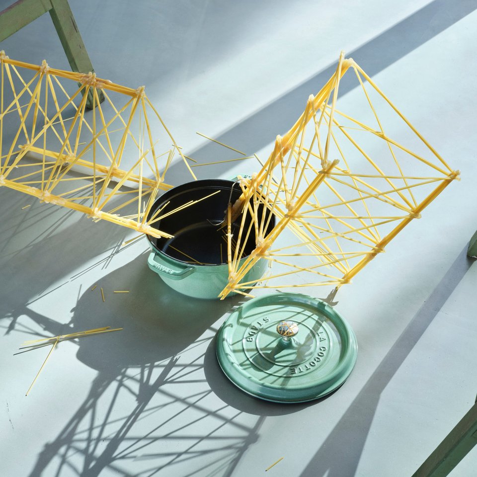 Darstellung einer Brücke aus Spaghetti, die zerbrochen ist, und Topf auf Boden