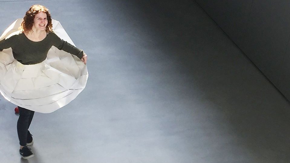 Studierende fängt bei Präsentation Bälle mit Papierkleid auf