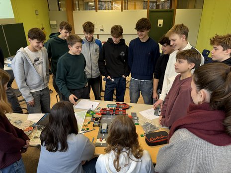 Students stand in front of a model: Joint workshop with students at Geschwister-Scholl-Gymnasium