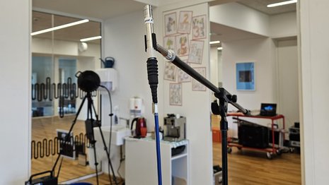Akustik-Messsituation in einem Klassenzimmer mit dem Lautsprecher im Hintergrund und dem Messmikrofon im Vordergrund