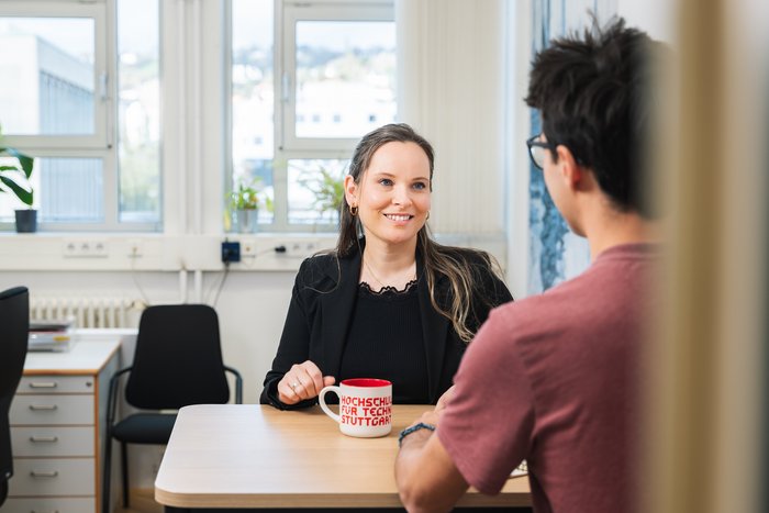 Zwei Mitarbeitende im Gespräch an Besprechungstisch