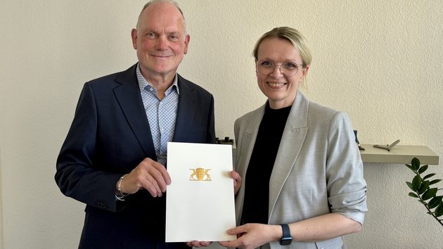 Brigitte Heintz-Cuscianne receives the certificate from Dr. Hans J. Reiter.