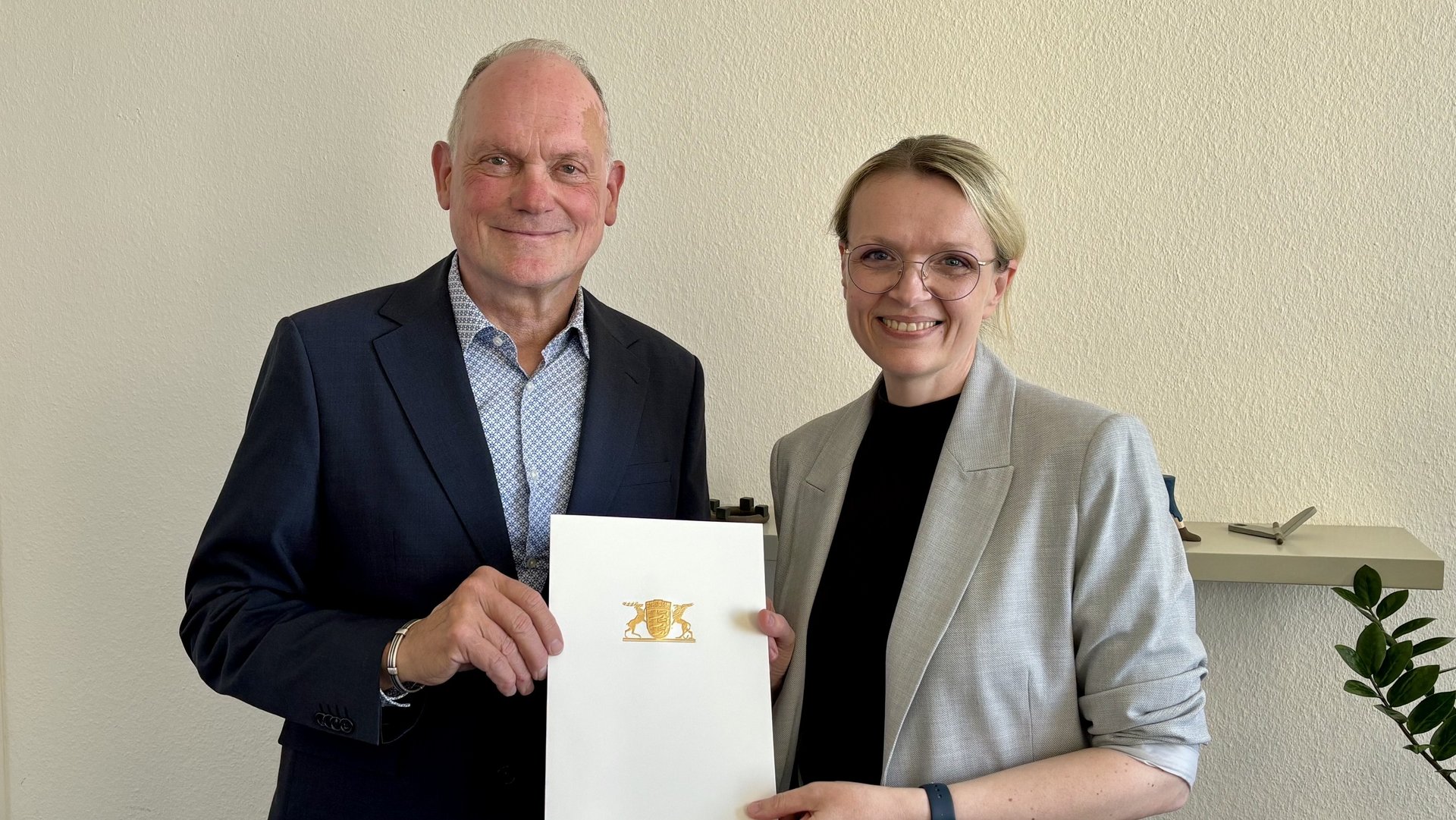 Brigitte Heintz-Cuscianne receives the certificate from Dr. Hans J. Reiter.