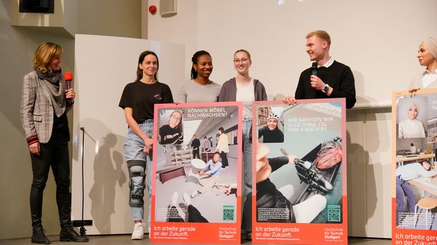 Studierende mit Postern auf einer Bühne