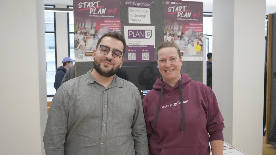 Zwei Studierende lachen in die Kamera